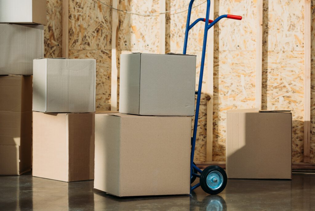 Cardboard packages and delivery cart in warehouse room