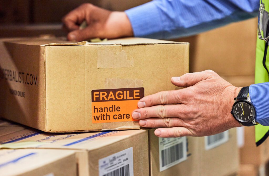 Shot of a unrecognizable man packing boxes in a warehouse